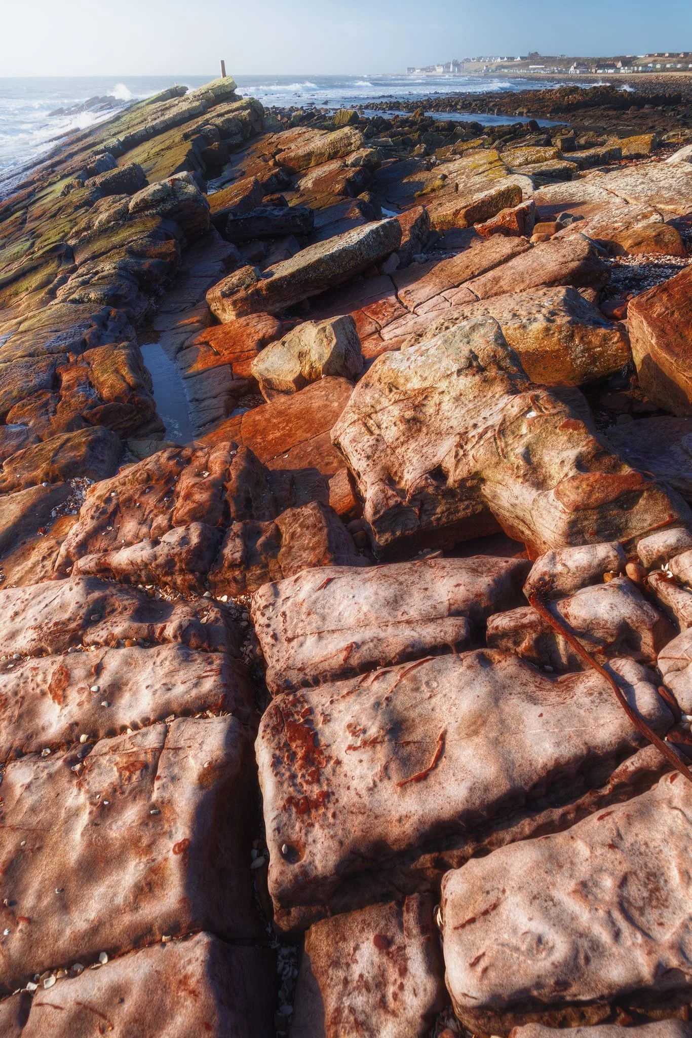 What you’re looking at is from a time between 359 and 299 million years ago. The reddish-brown rocks contain a lot of iron oxide and were formed when Scotland was near the equator in a warm climate. The layers of sandstone and mudstone show how they were built up in ancient shallow seas and river deltas. Over the years, shifts in the earth’s crust created the rectangular patterns you see, and the coast being worn away by waves shaped this impressive platform.