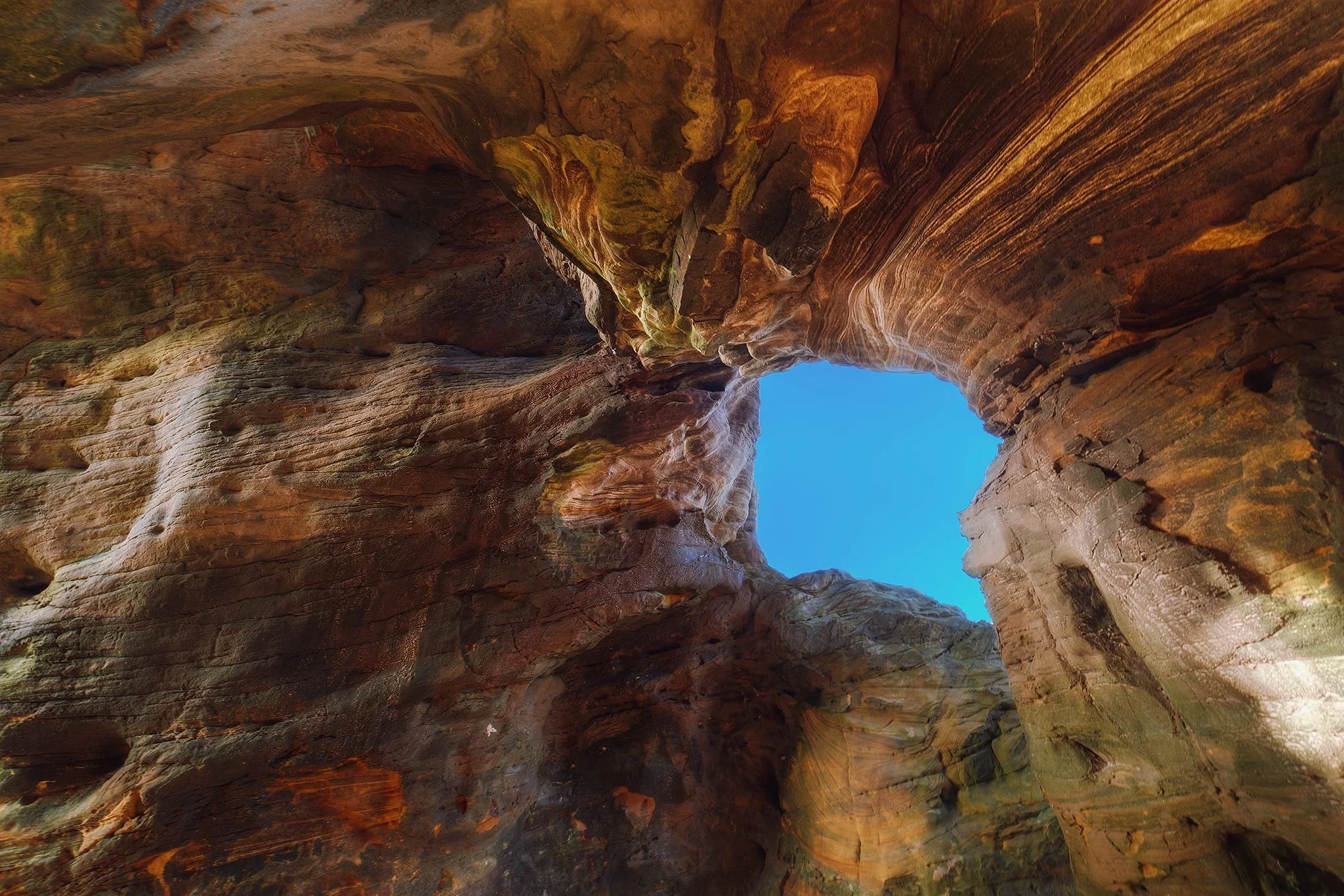 Like an over-excited child, I equipped my ultra-wide 14mm lens and went hunting for compositions. In the bigger cave I spotted a small “window” and used the incredible patterns and formations in the rocks to serve as a compositional leading line.