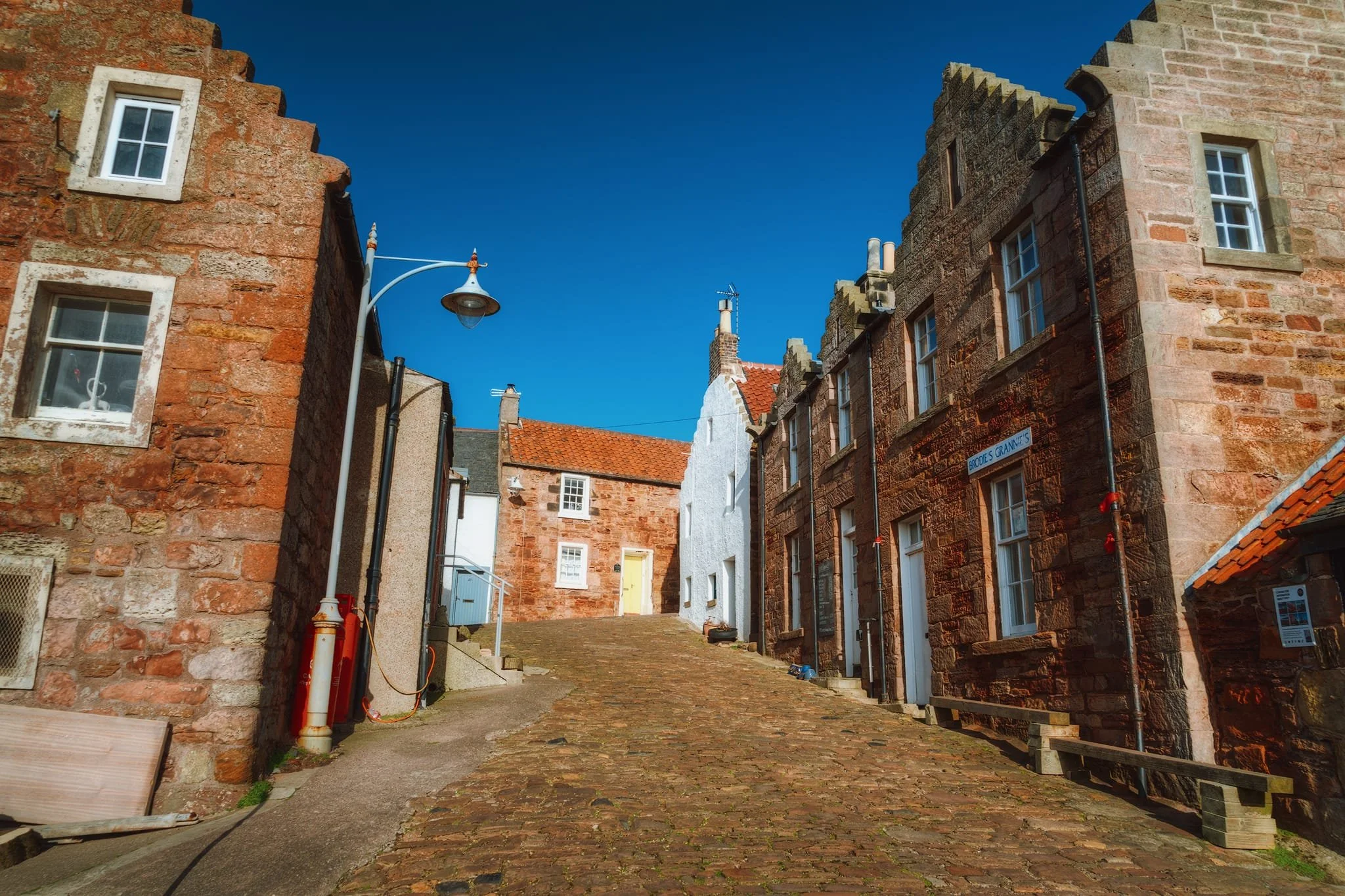 Looking up the still-cobbled King Street. Here another architectural characteristic of eastern Scottish buildings becomes visible: crow-stepped or “corbie” stepped gable-ends. The term “corbie steps” is more common in Scotland; the Scots word “corbie” meaning “crow. We probably nicked this design idea from Belgium and the Netherlands.