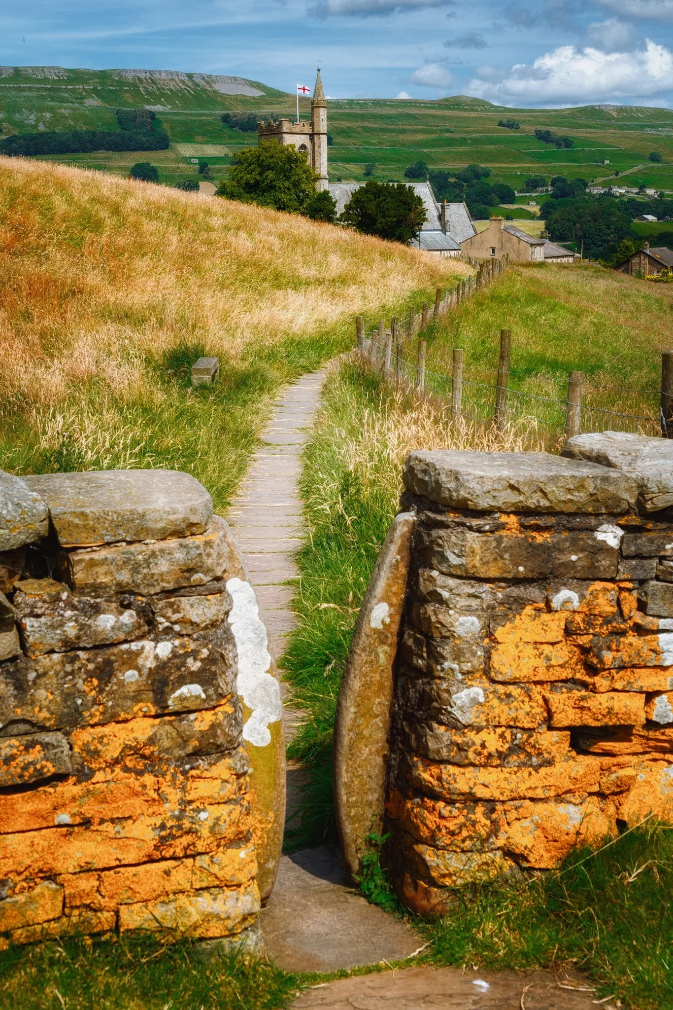  St. Margaret&rsquo;s Church flying the St. George&rsquo;s flag, the Pennine Way serving as a leading line into the composition. In the distance are the High and Low Clints of Stags Fell. 