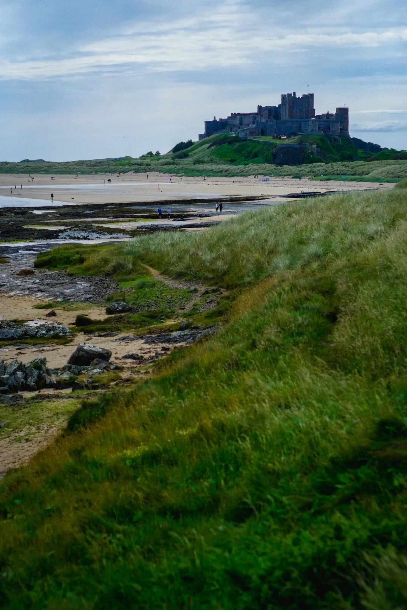 The hulking might of Bamburgh Castle, standing protectively over the coastline and sea.