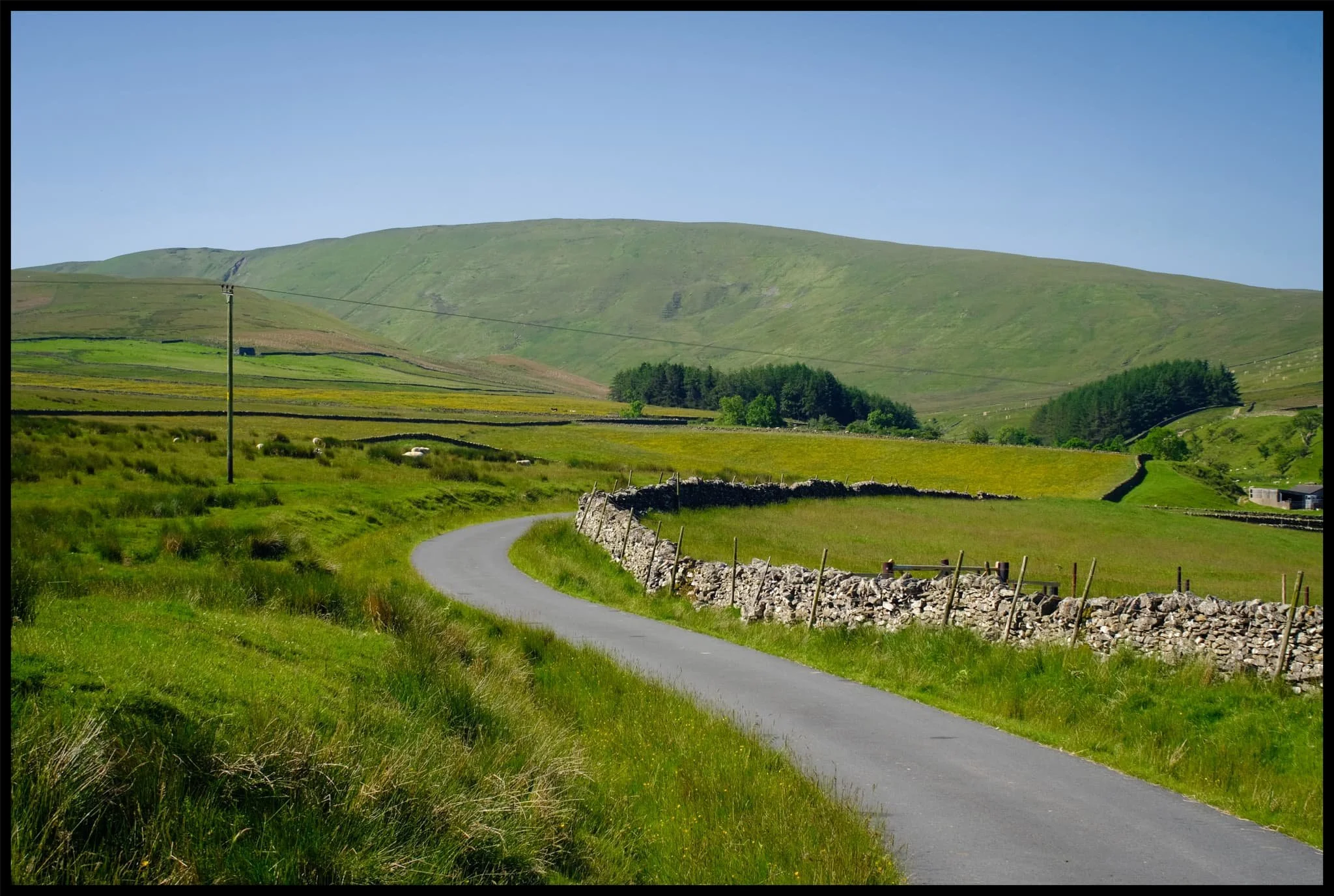  The country lane to Bowderdale village and ultimately Bowderdale itself. The fell in the distance is West Fell (542 m/1,778 ft), which flanks the western side of the valley. 