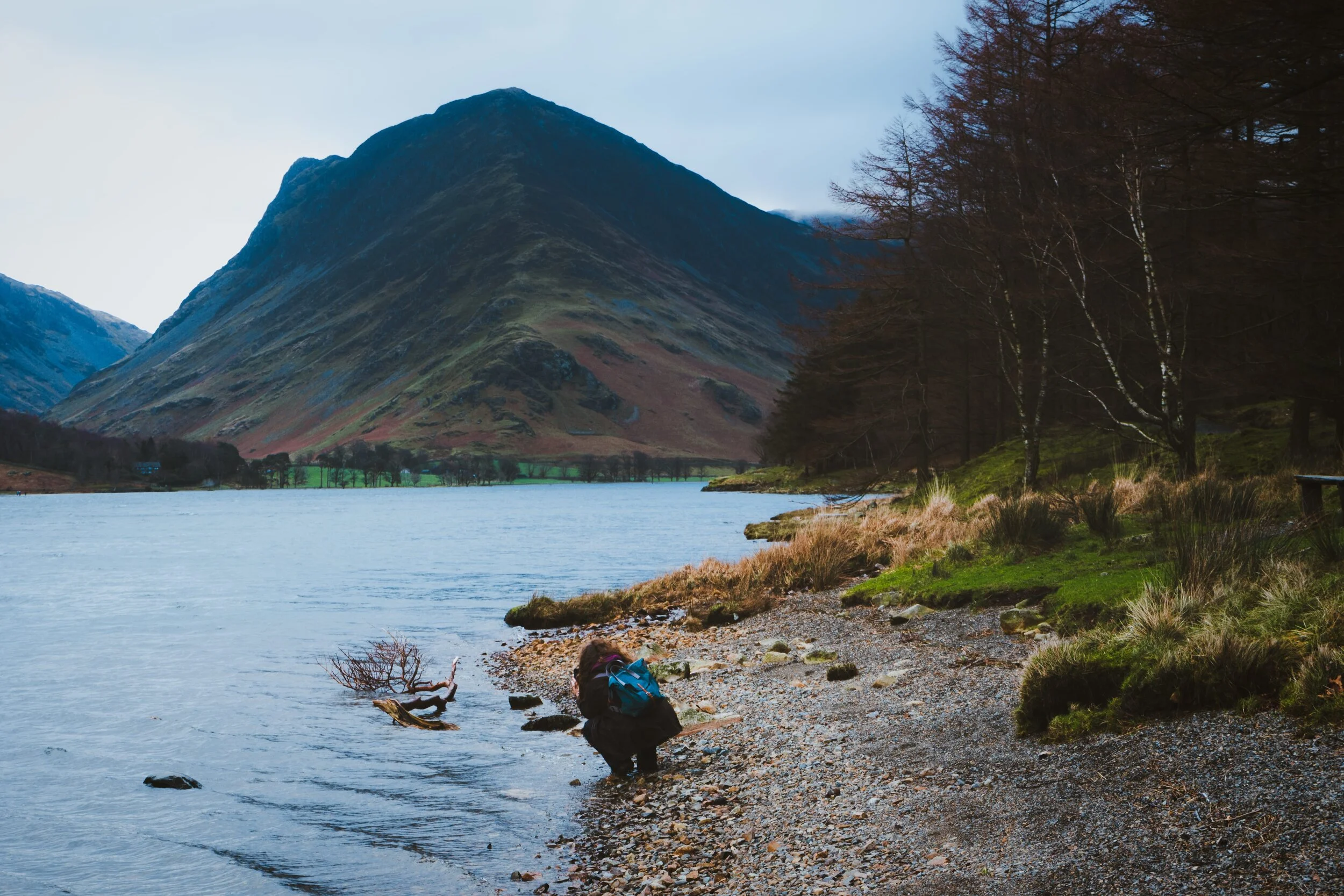 My little Lisabet, crouching by the shore of Buttermere to get a composition. Looming in the distance is the beautiful Fleetwith Pike.