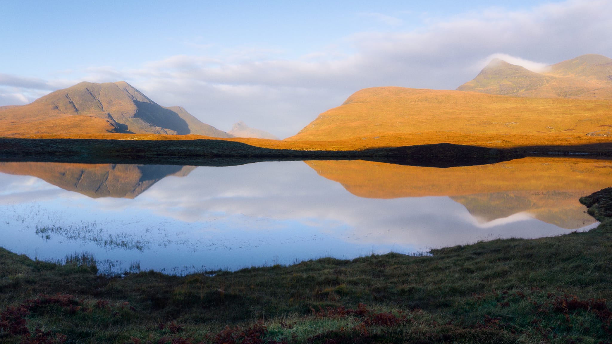 On another day, heading towards Lochinver one early morning, we hurriedly stopped at one of the A835’s many parking areas as our eyes caught a glimpse of perfect reflections. Here, across a still Lochan an Ais, the rising sun drenched Stac Pollaidh, Cùl Beag, and Cùl Mòr in beautiful autumnal orange. A scene I’ll never forget.
