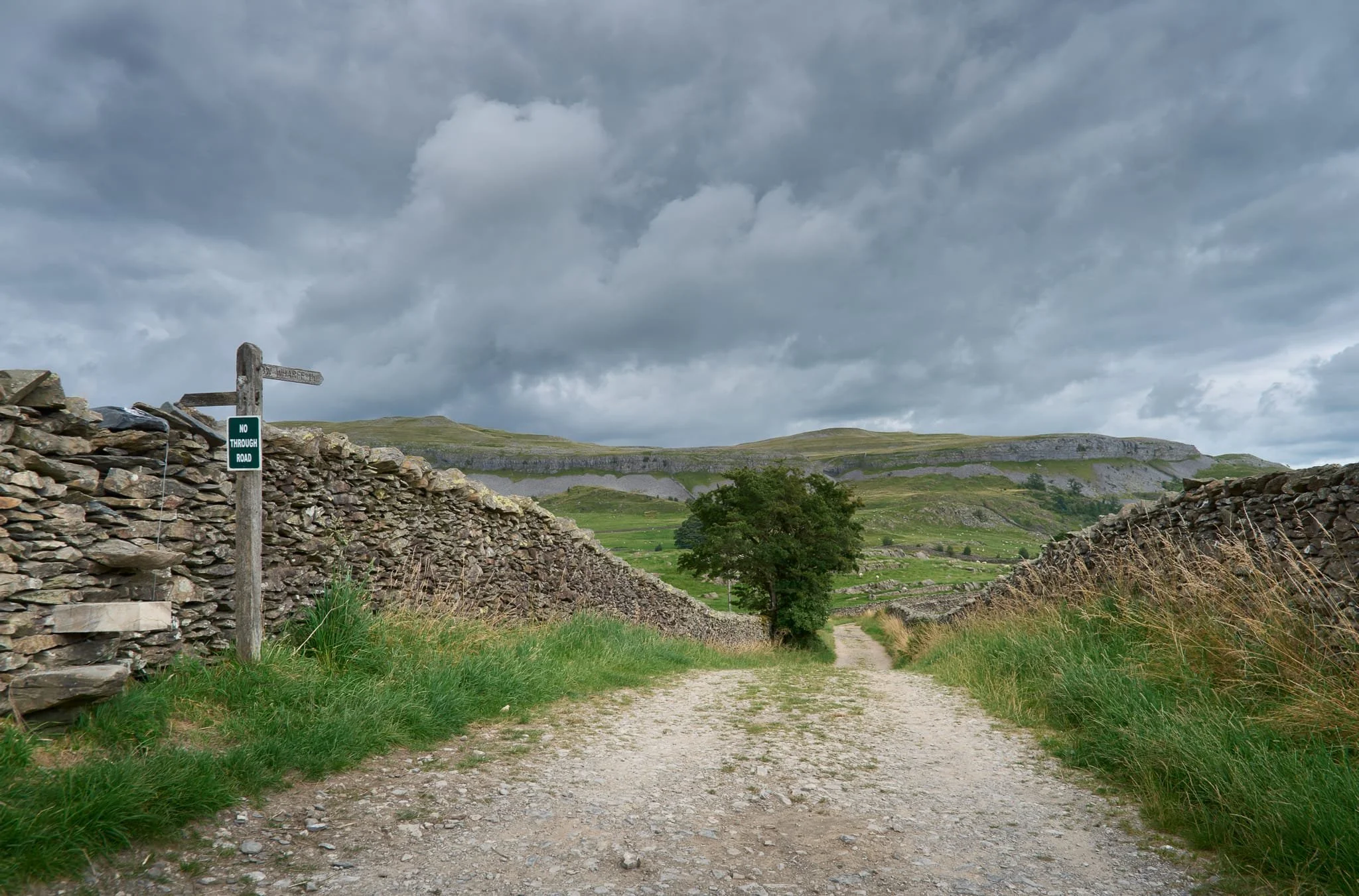  The way southeast to Wharfe along the Dales High Way. Above, stormy clouds continually threatened to heave it down. 