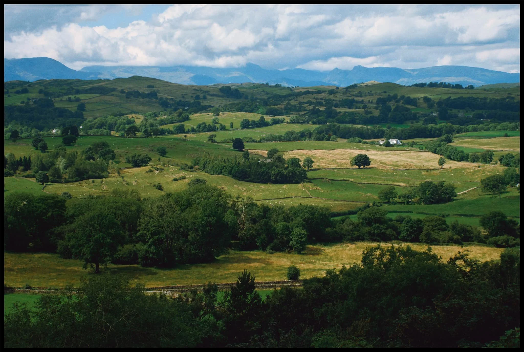  Directly west from the summit, the rolling Lyth Valley is capped by the distance Lake District fells. 