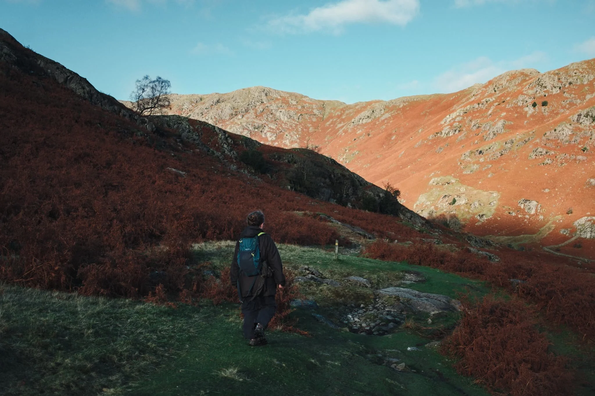  My lovely Lisabet leading the way, with the sun drowning the fells in warm light. 