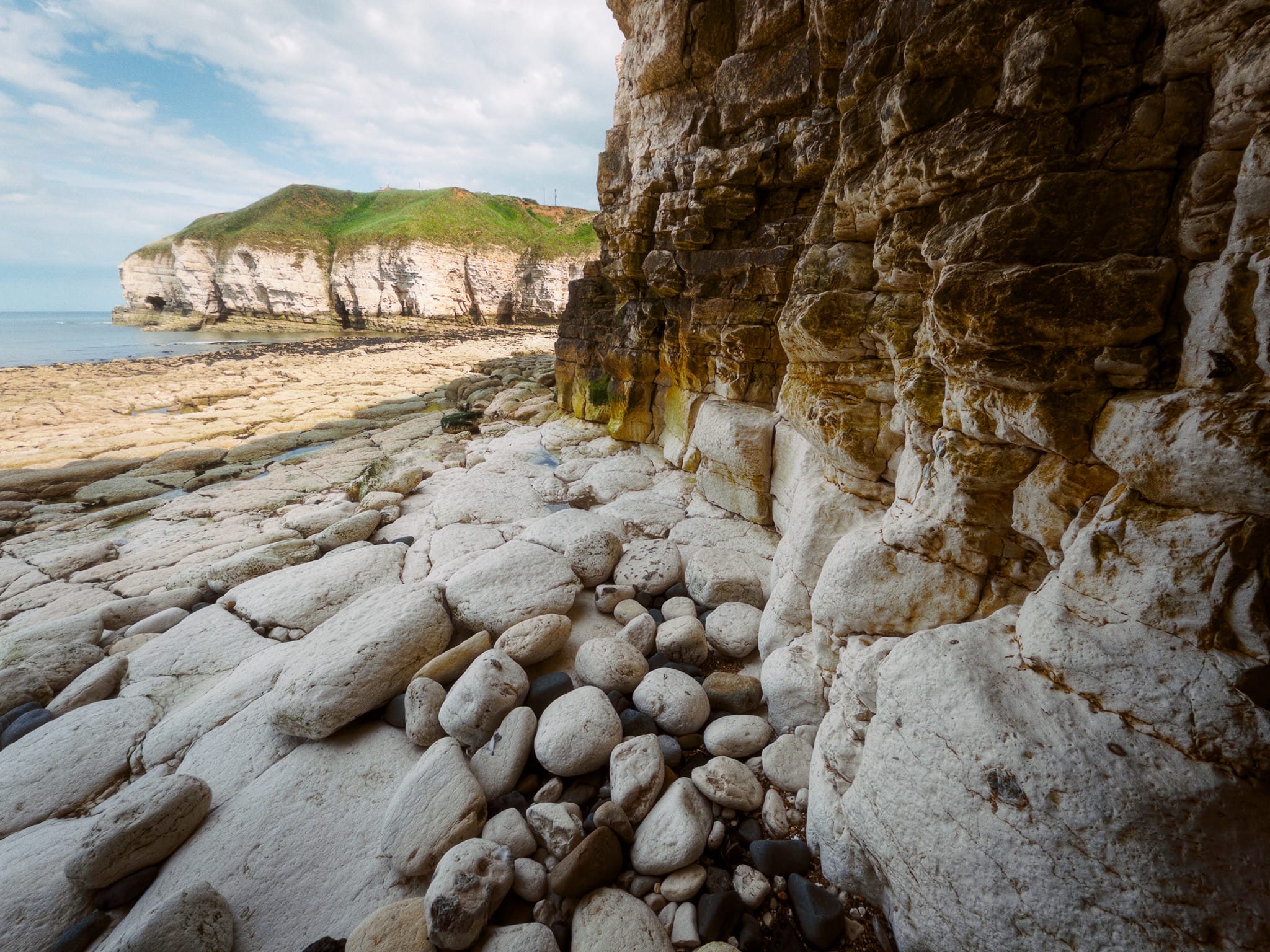 I tucked myself deep under the cliffs to get the contrast between shade and the light striking Thornwick Bay&rsquo;s eastern cliffs. A nice contrast of dark and light, smooth and blocky, boulders and pavement.