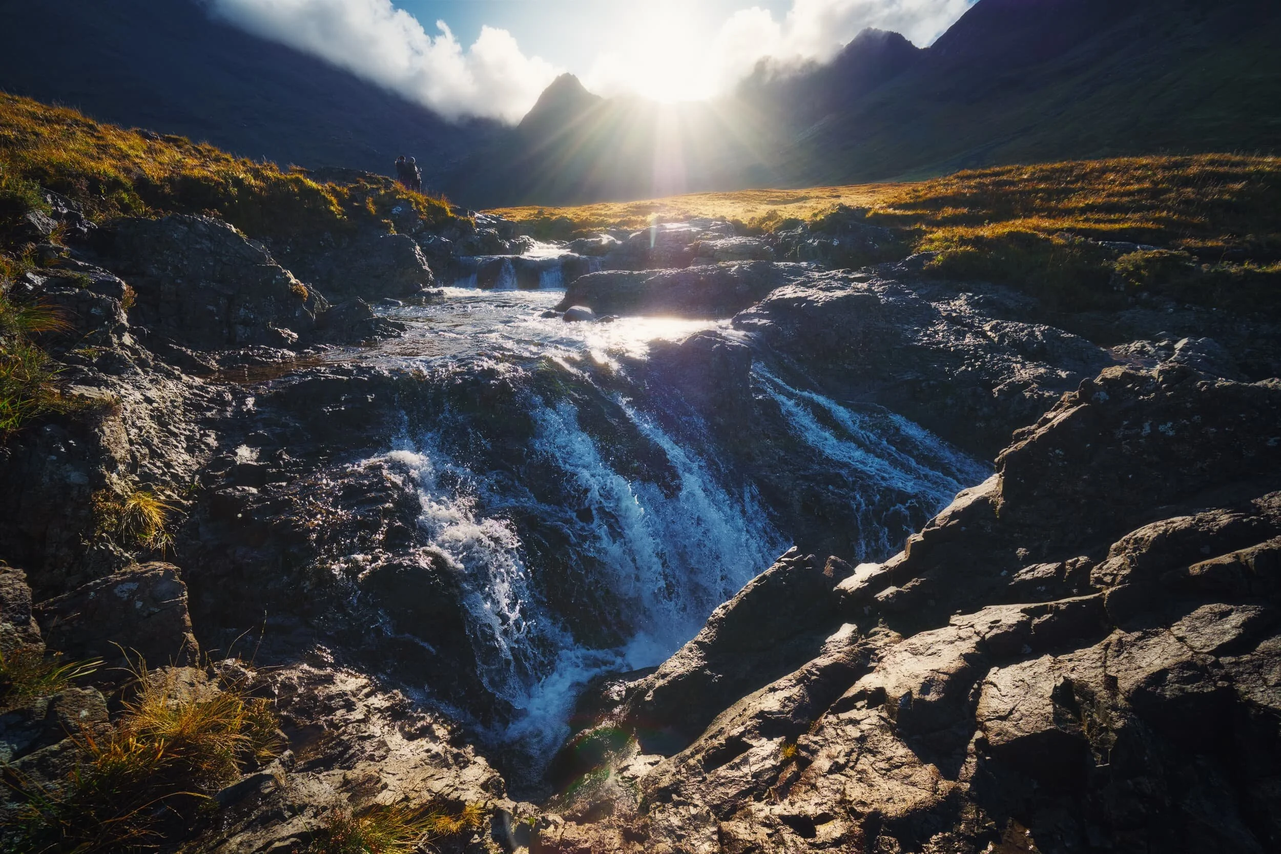 One of the last cascades on the  Allt Coir&rsquo; a&rsquo; Tairneilear  before the river flattens out directly underneath  Sgùrr an Fheadain . Beautiful golden light picks out the various ridges and shelves of rock around the river. 