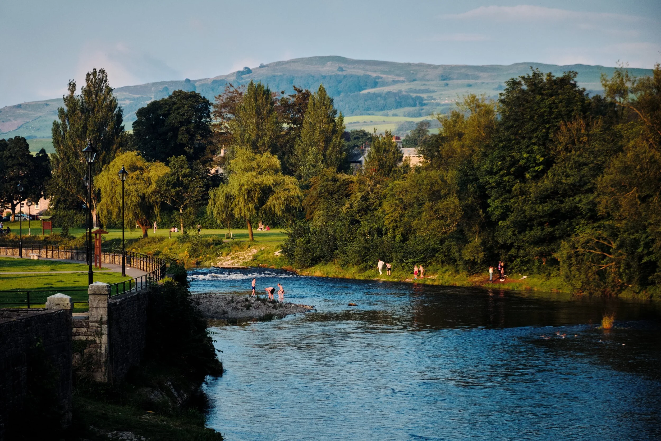 Teenagers play around and cool down in the River Kent.