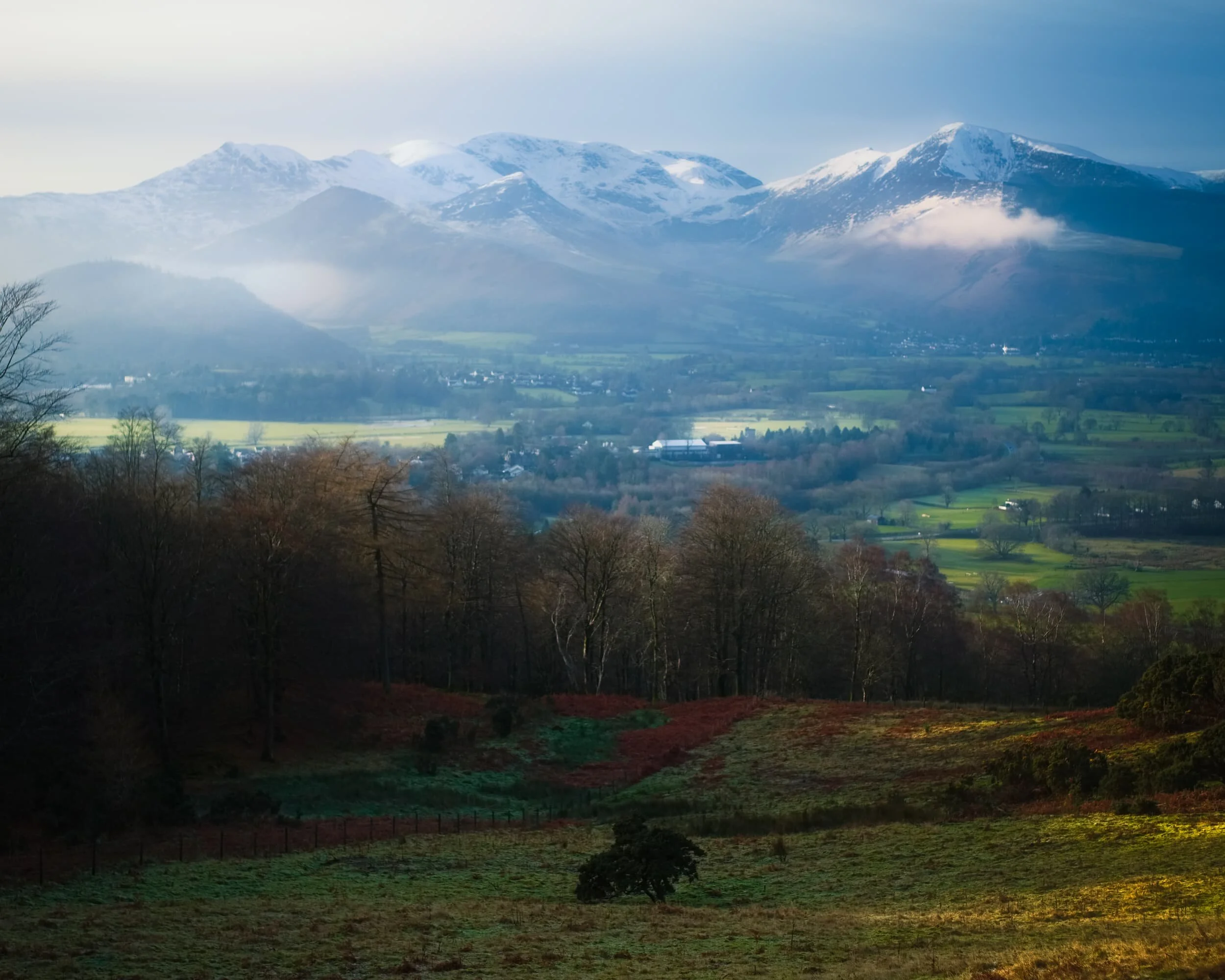 As we ascended up the steep section of the Cumbria Way, the views looking back west and southwest grew more impossible to resist photographing. The sun was too weak to burn away the morning&rsquo;s temperature inversion, leaving floating tufts of mist to meander around the fells. 