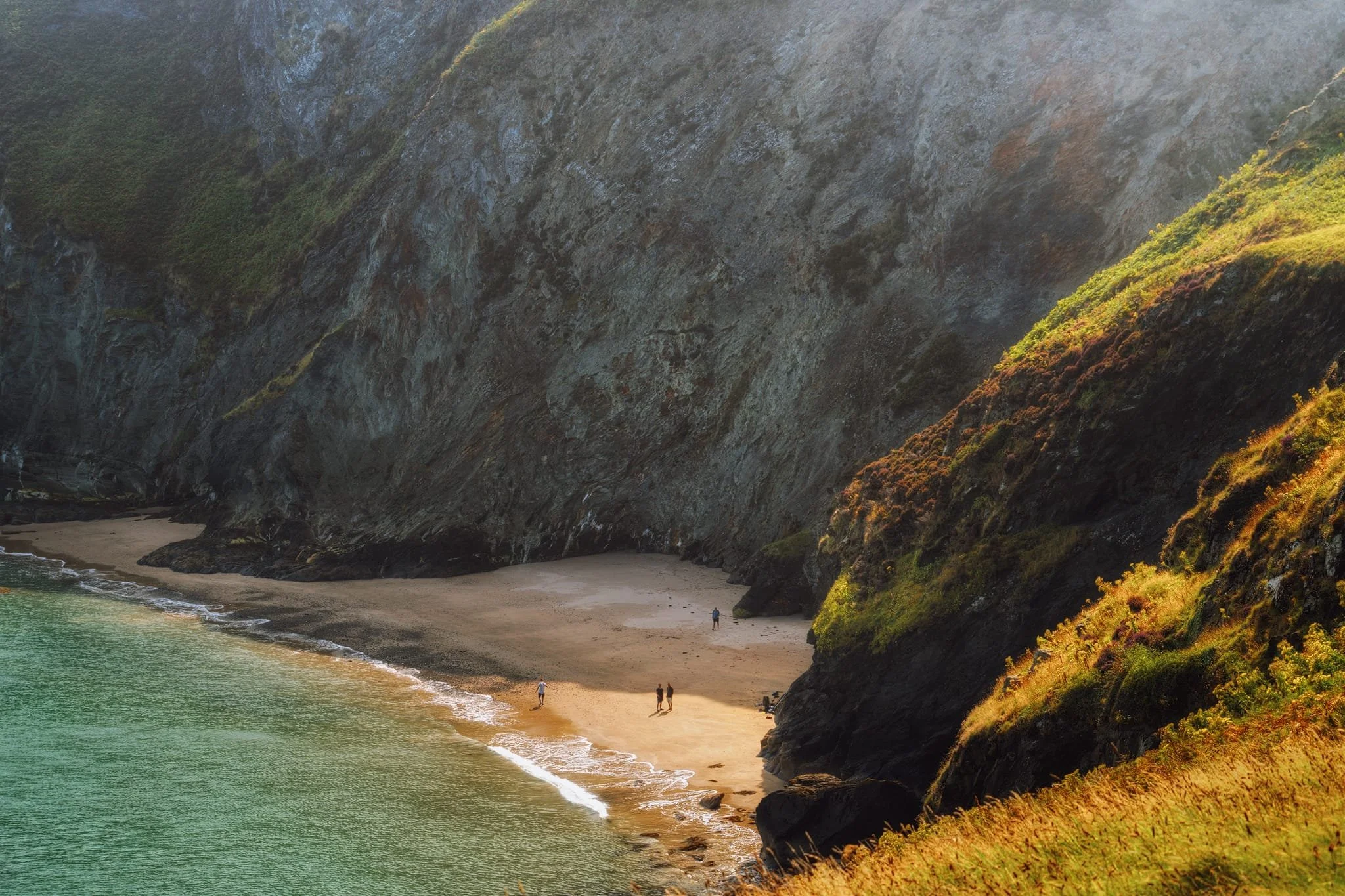 From the eastern cliffs of the peninsula, I zoomed in and down to the beach of  Traeth-yr-ynys  directly below the sheer cliffs of  Pendinaslochdyn . Folk were milling about on the beach; presumably they accessed it via kayak or boat of some nature. 