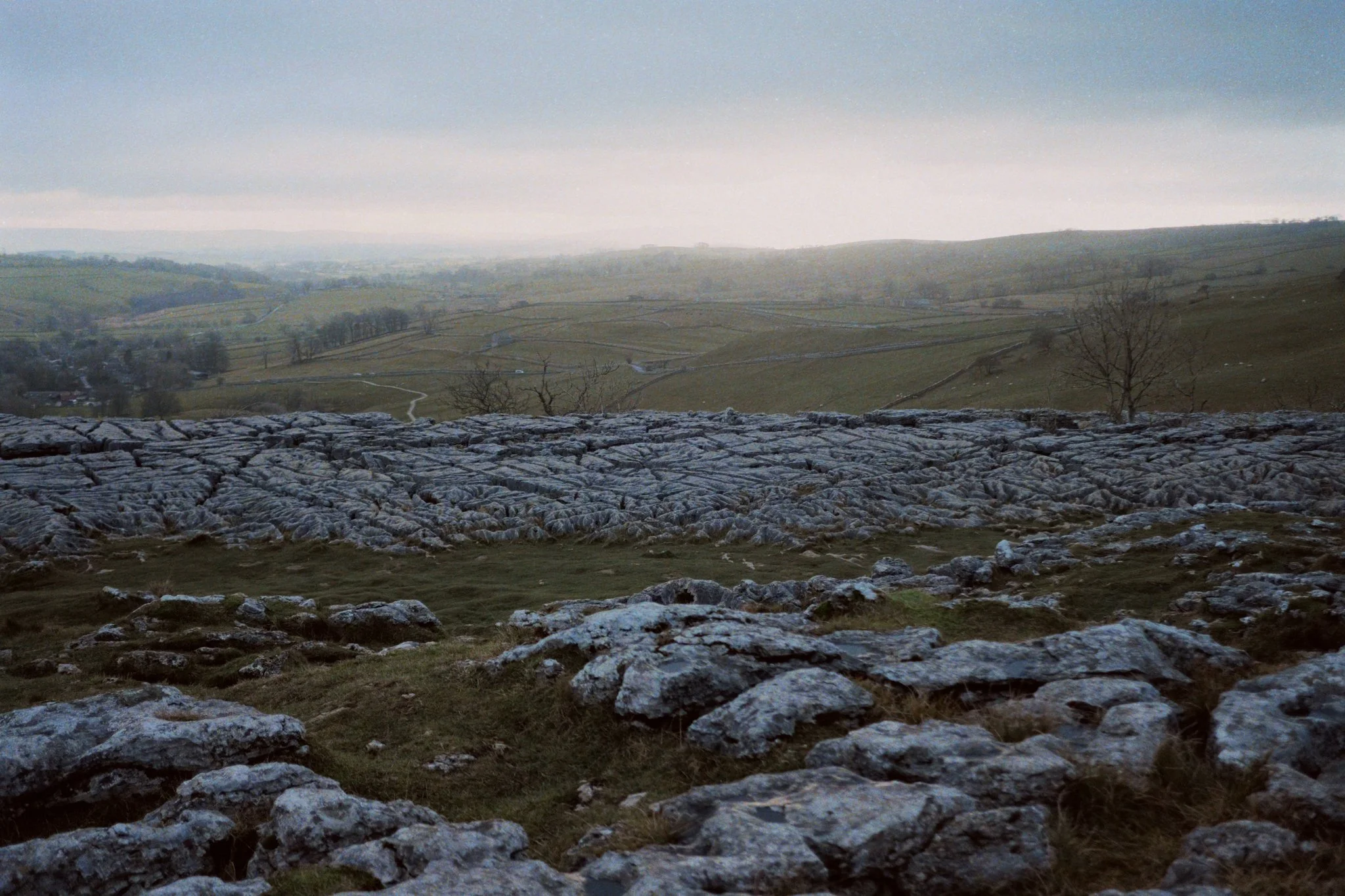 Up on Malham Cove, the views are extensive, and we can see all the way across Malhamdale, beyond the Aire Gap towards the smooth hills of the Forest of Bowland in Lancashire. Even with the landscape being as epic as it is, the light was also wonderful.