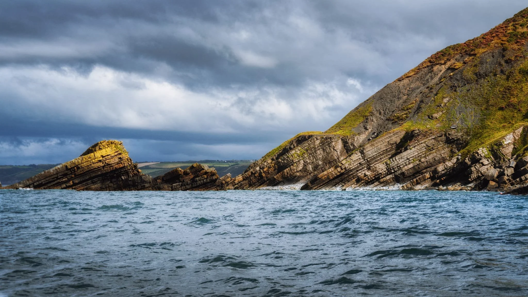  On our little boat we ventured north out of the harbour and head west around cliffs of New Quay Head. Here we could see the results of coastal erosion in these tilted folds. 