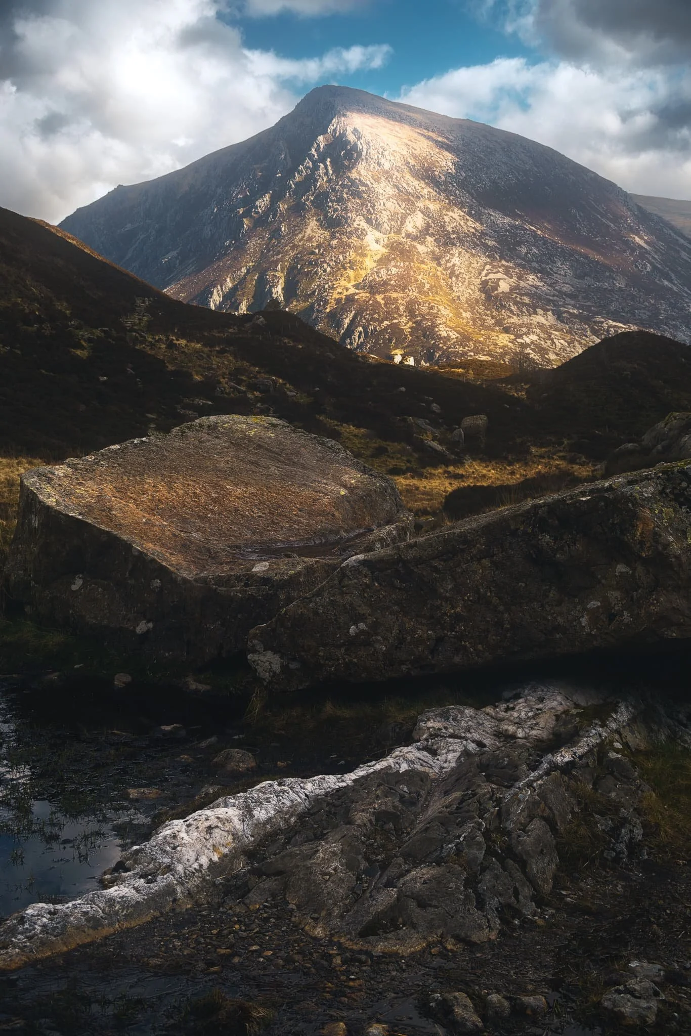  Walking along the western section of the trail away from the Idwal Slabs, the profile of Pen yr Ole Wen (978m/3,209ft) comes into view. Here, I spot two giant slabs of rock that provide a nice foreground interest as Pen yr Ole Wen gets some lovely morning light. 