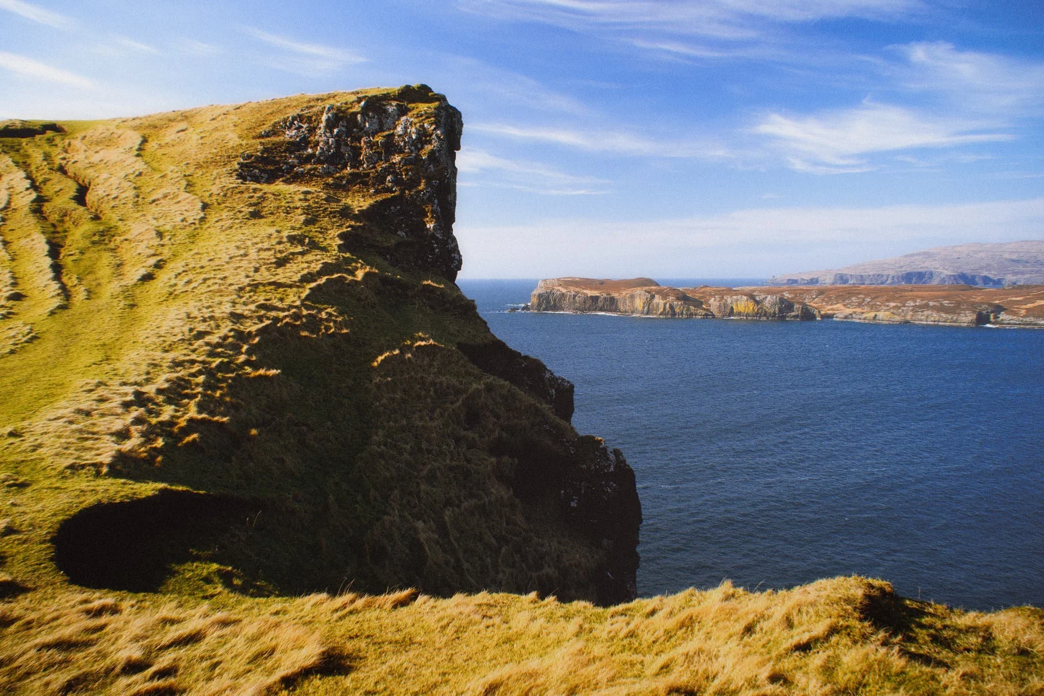  Looking back at the tallest cliff, it&rsquo;s contrasty shape and shadow is used to frame the distant island of Wiay and  Duirinish  cliffs. 