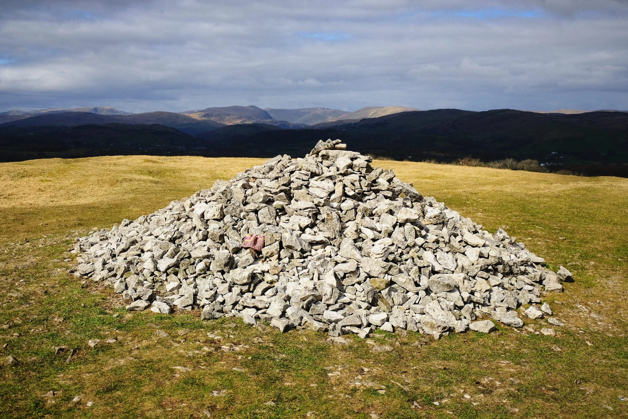 The summit of Cunswick Fell (175 m/574 ft), with the Kentmere fells in shadow in the distance.