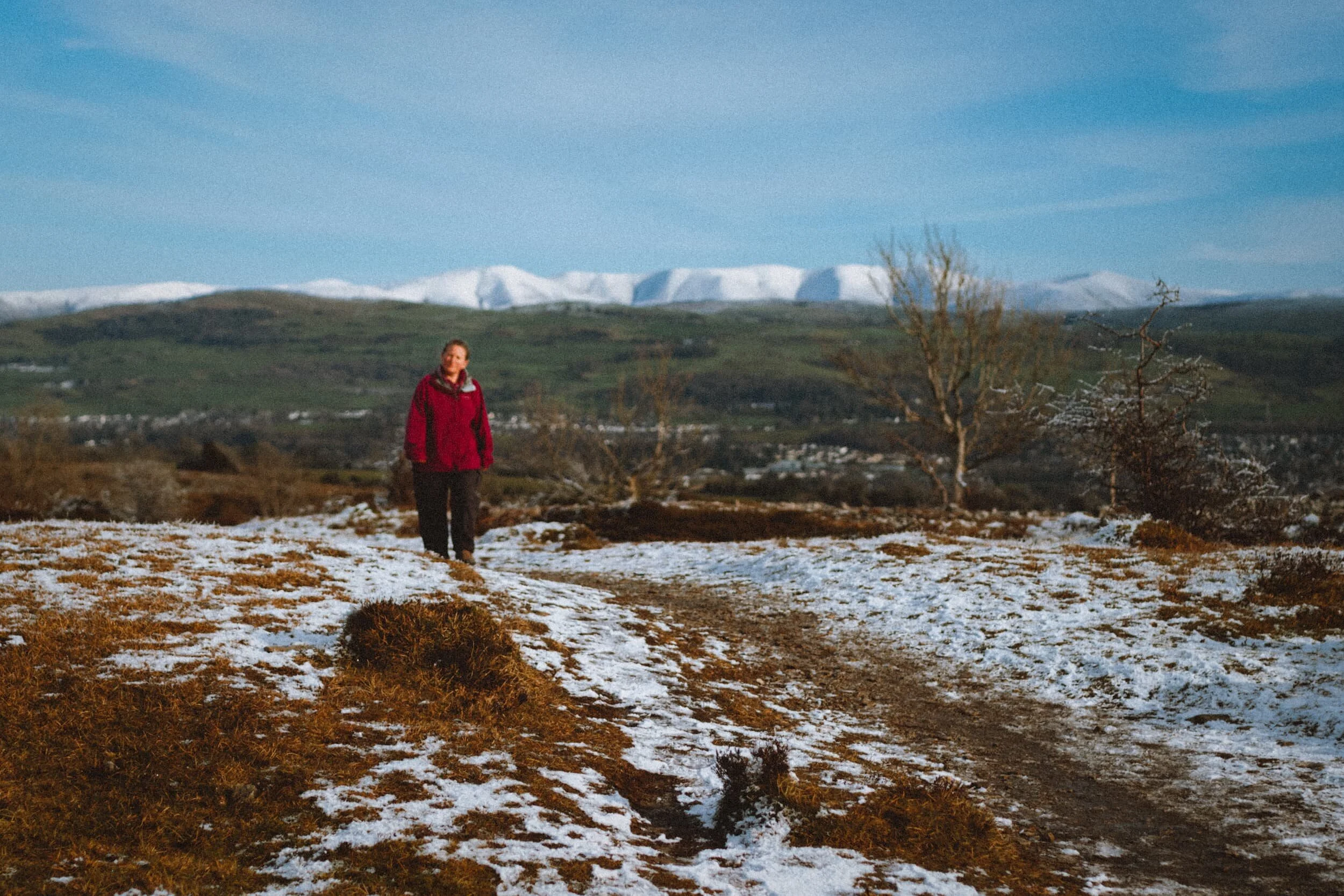 The views open up the higher we climb. Looking back at the way we came, I frame this shot of Lisabet with the wonderful snow-covered shapes of the Howgills in the distance.