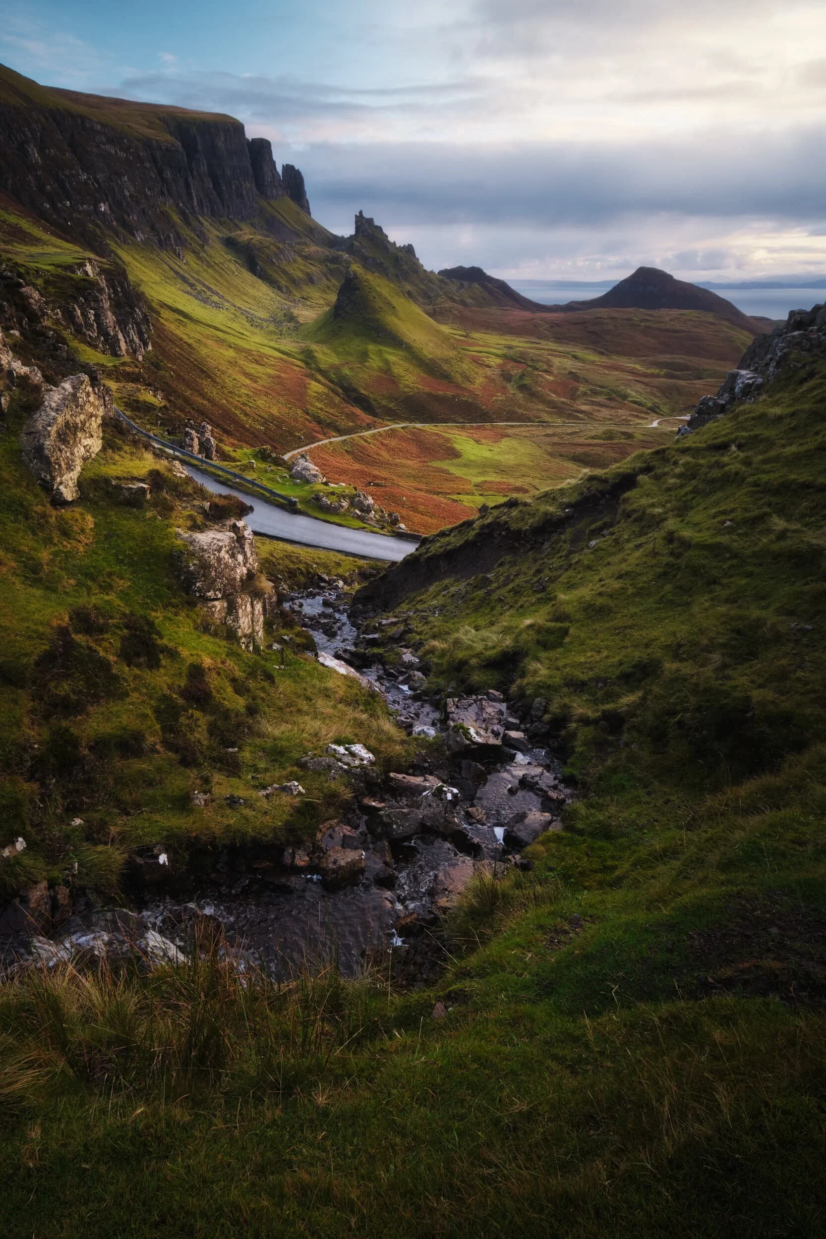  As we clamber back down the ridge we cross a meandering little stream, which I use as a leading line towards the northern section of the Quiraing. Those rock formations just don&rsquo;t seem real. 