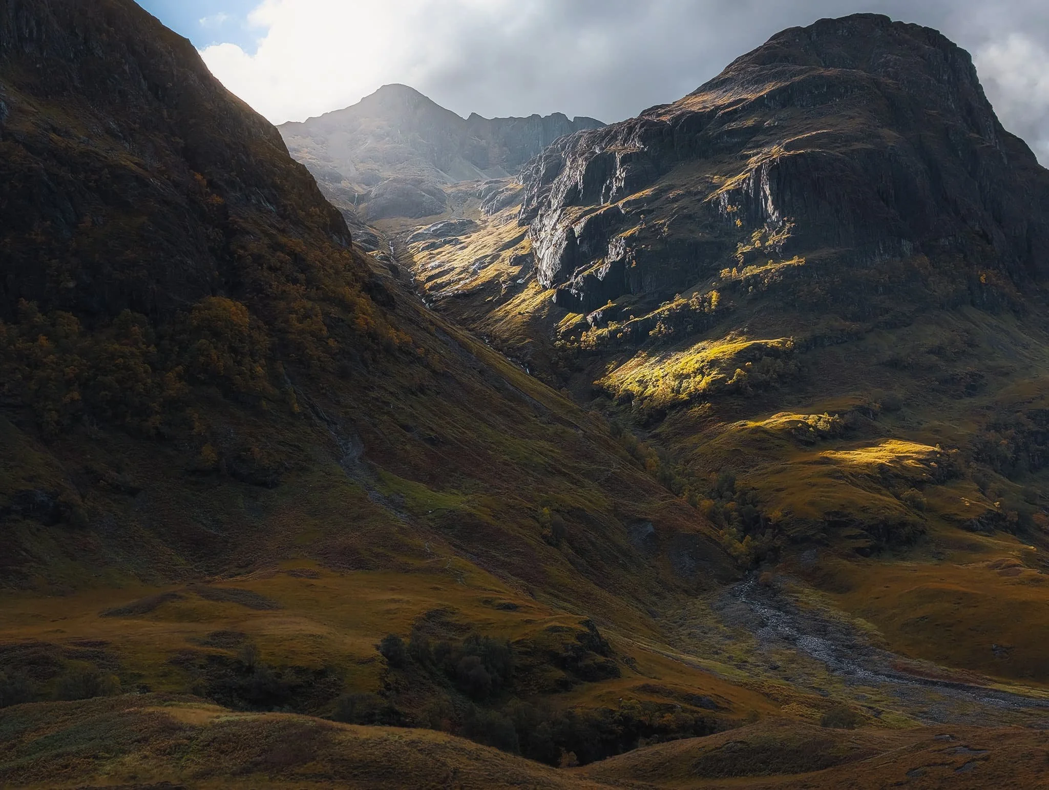  Autumnal light piercing between  Geàrr Aonach  and  Aonach Dubh , illuminating the crags of  Corrie nan Lochan . A perfect moment. 
