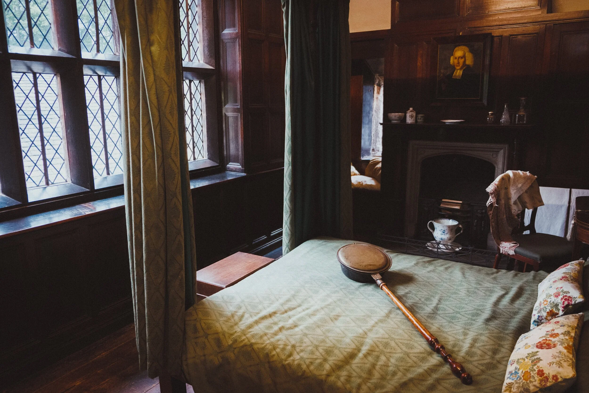 The Oak Bedroom. On the bed is a Bed Warmer. Before central heating houses were often cold and damp in the winter. The warming pan was used in beds to warm them and get rid of the damp. It was filled with hot charcoal or ashes from the fireplace and then pushed into the bed.