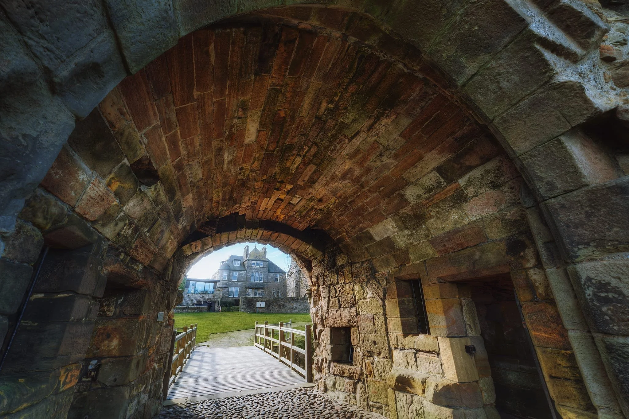  Looking through the entrance to the castle back towards the town. Towards its latter years, the castle was the home of Cardinal David Beaton, Archbishop of St Andrews, the last Scottish cardinal before the Reformation. Cardinal Beaton was not popular, and had no issue using the wealth of the church as his own. Additionally, courtesy of several mistresses, he fathered around 20 illegitimate children, many of whom he later gave well paid positions in the Church. He came to personify everything corrupt and in need of change in the Catholic Church. Eventually he was stabbed to death, mutilated, and hung from a castle window, before being dumped in the castle&rsquo;s &ldquo;bottle dungeon&rdquo; and covered in salt to &lsquo;keip him frome stinking&rsquo;. 