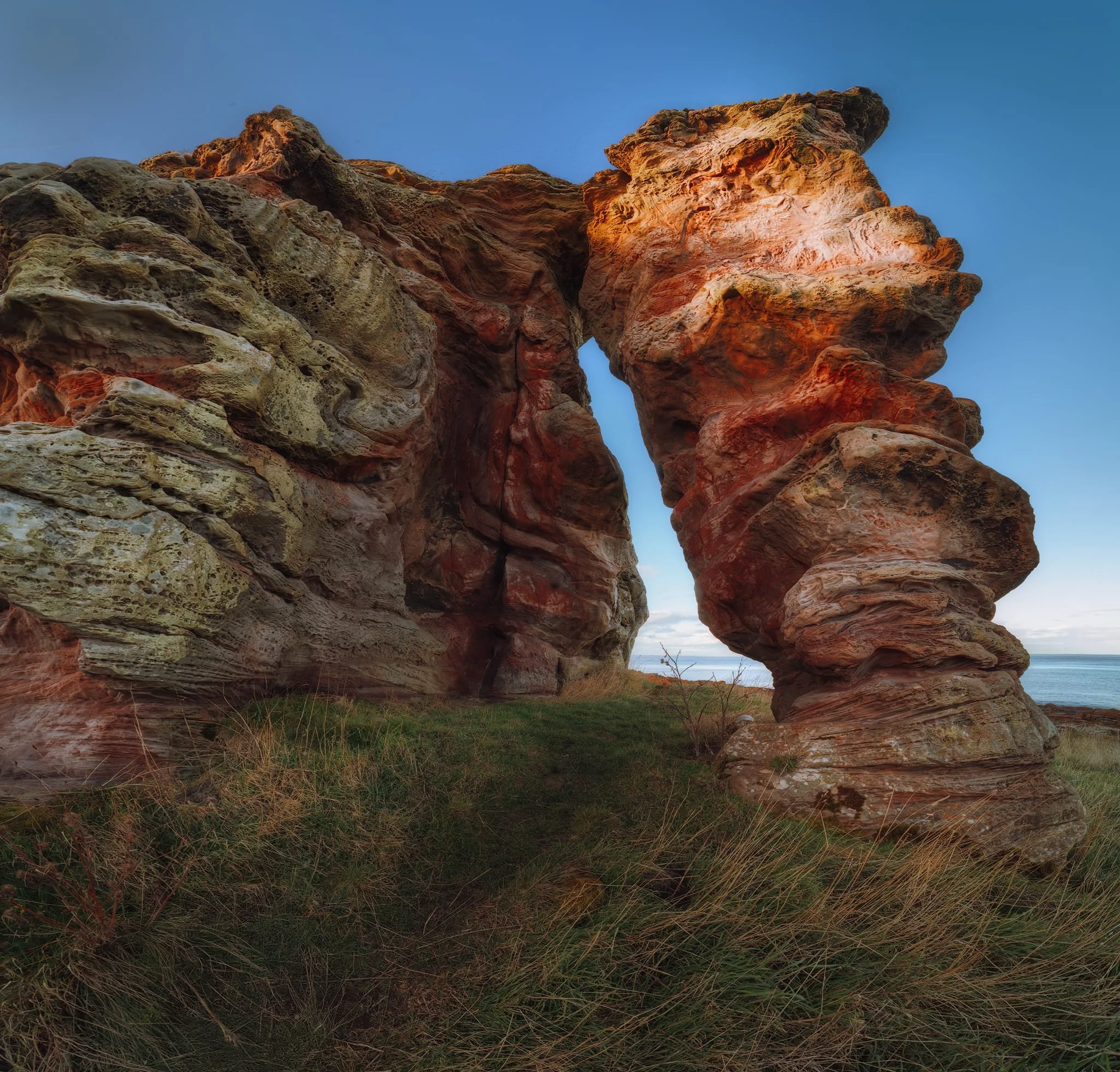   This  is Buddo Rock. It&rsquo;s a stack of pink sandstone that was once part of the cliffs along the coast; a remnant of a former sea cliff that formed around 15,000 years ago. The formation is a good 15 m (50 ft) tall, so even with my 14mm ultra-wide lens attached I still couldn&rsquo;t get the whole thing in. This was image was achieved by shooting seven landscape shots, stacked top to bottom, for a massive vertorama. 