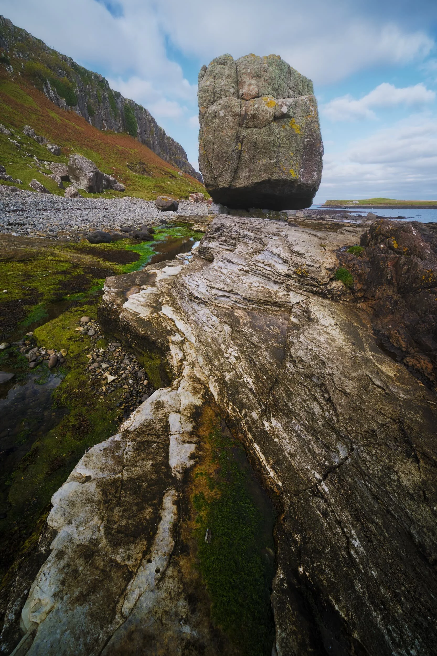 A glacial erratic remains perched on the raised bed of rock at An Corran , Staffin.