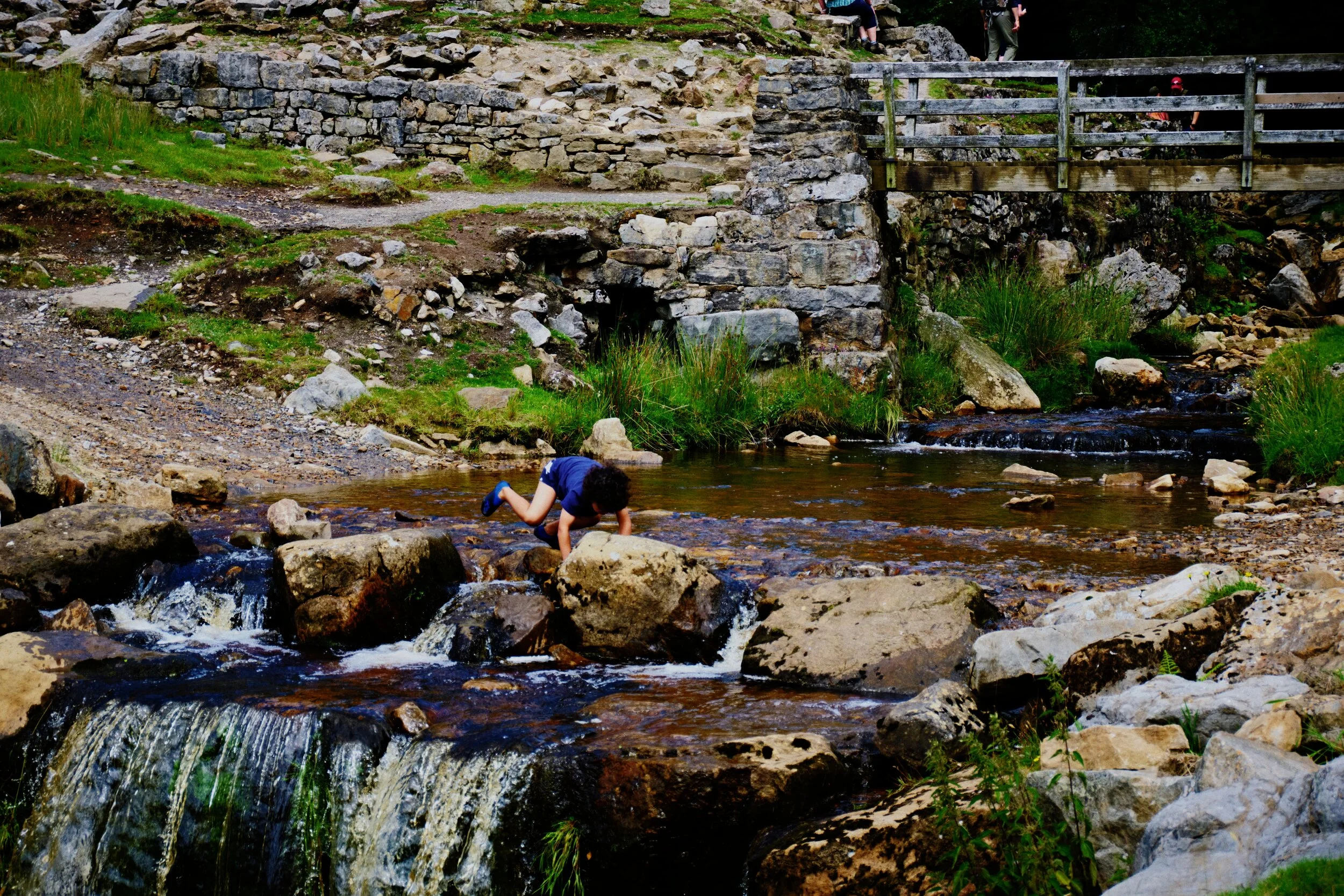 A highly excitable child clambers across the beck of Swinner Gill.