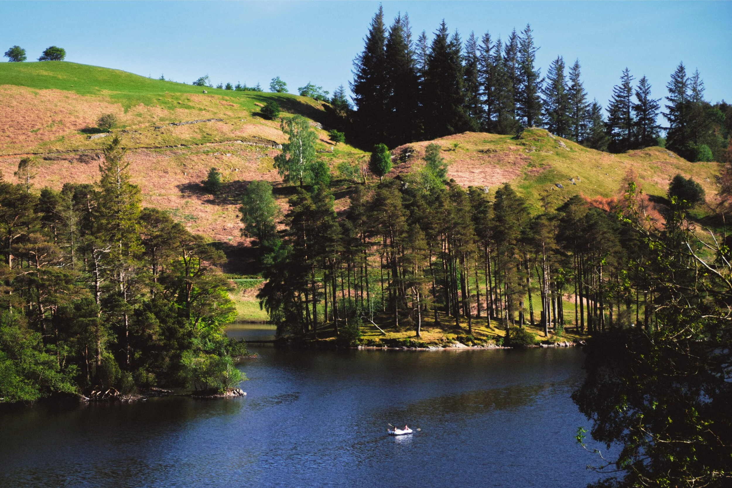 Peacefully rowing in a dinghy on the calm blue waters.