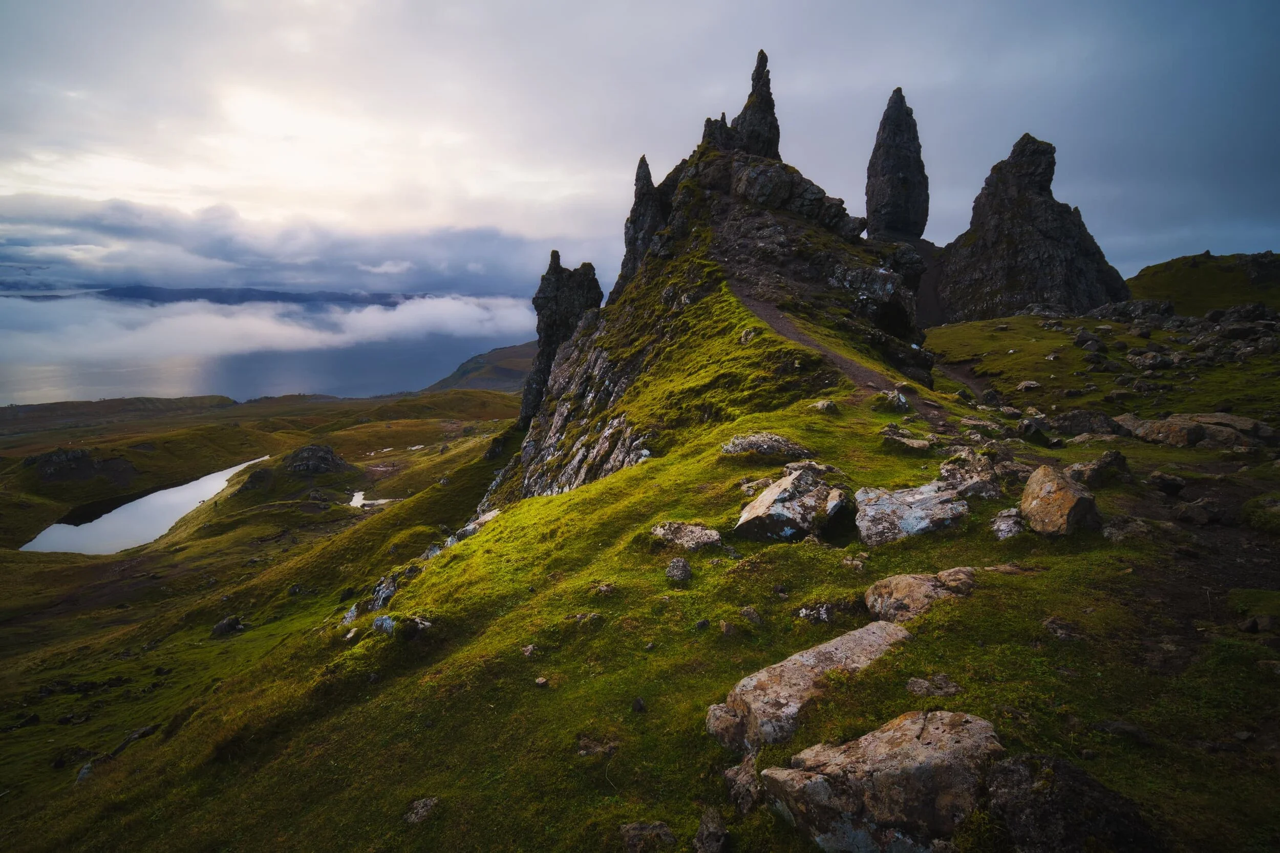 The more “classic” or “traditional” view of the Sanctuary rocks below the cliffs of the Storr. The temperature inversion was thickening up, along with the cloud cover, but a bit of sunrise light broke through to illuminate the scene.