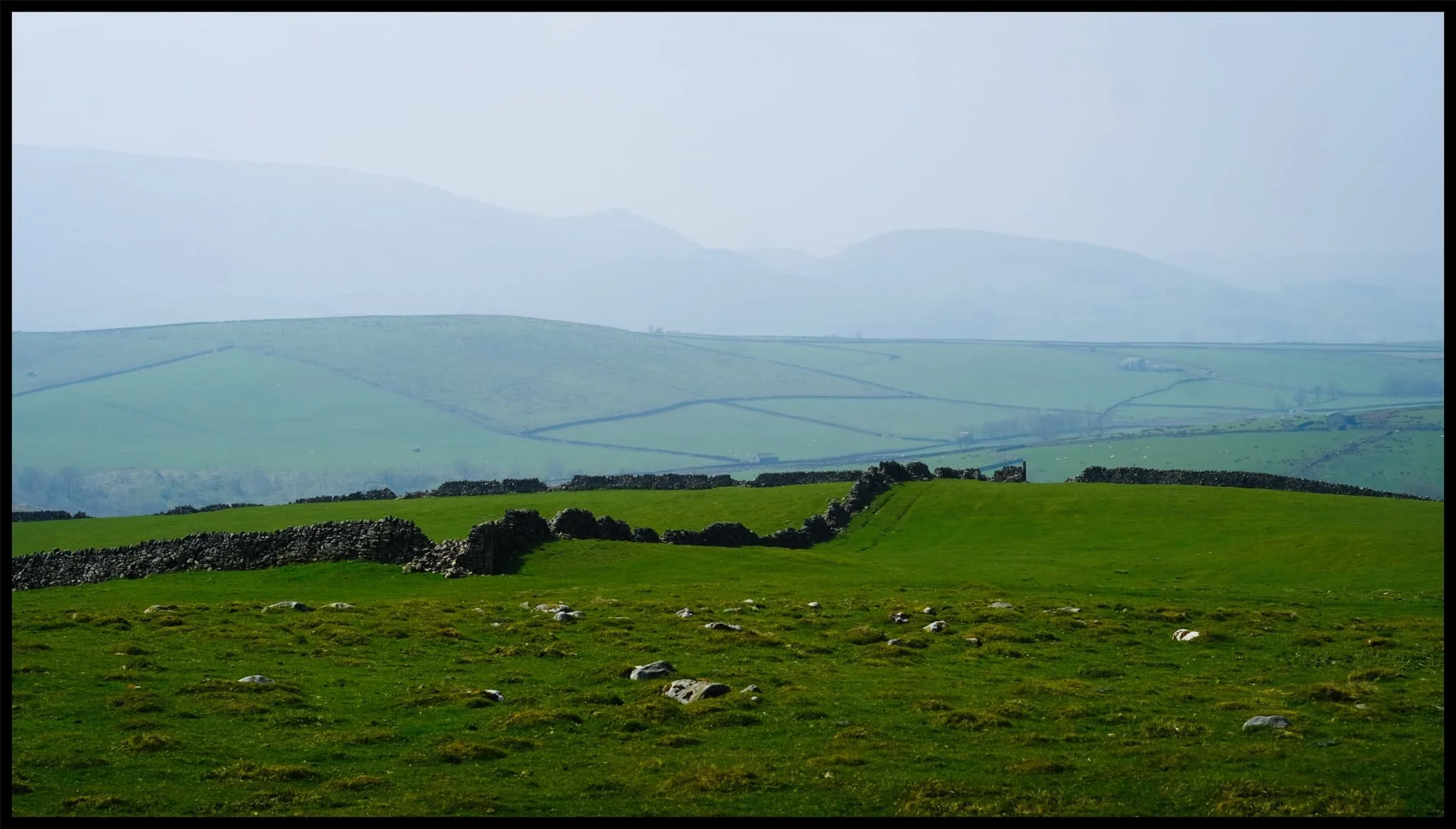  After Burnsall, I identified a handy little parking area off the B6265 that would serve as the starting point of our hike to, and up, Trollers Gill. The day was bright and sunny whilst also hazy, lending a wonderful sense of intrigue and distance to photographs. Up on the moorland high above Appletreewick, views extended for miles and miles. 
