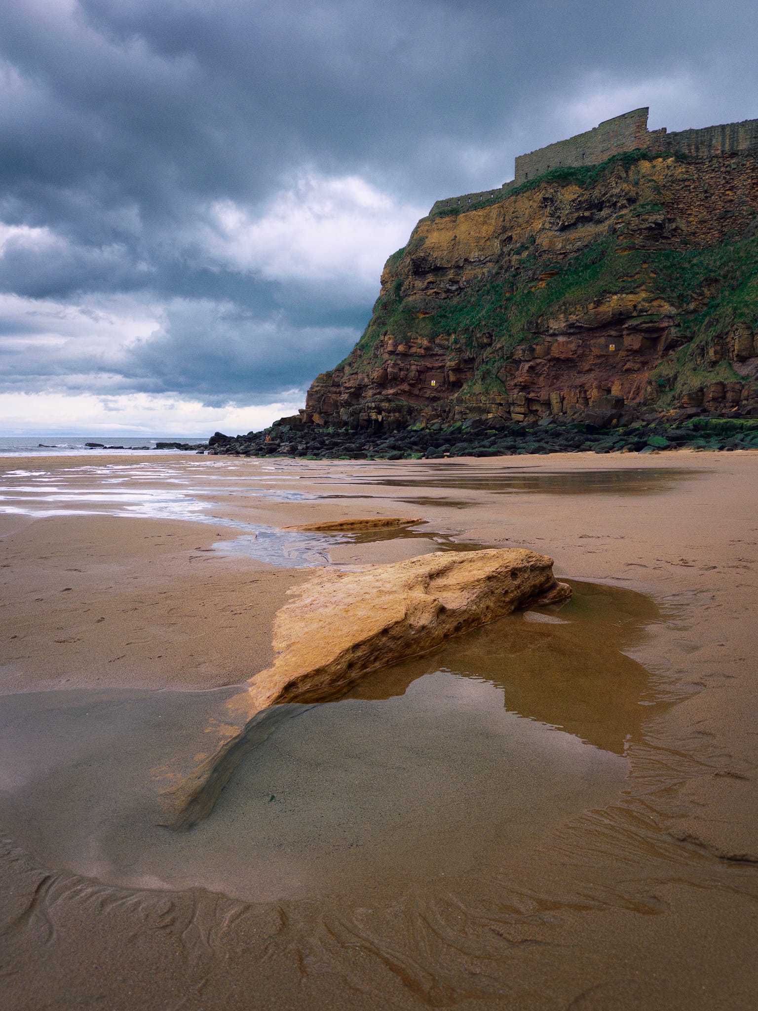 We immediately made our way onto the beach of King Edward&rsquo;s Bay, with the imposing cliffs and Priory above us. The tide was out but it was due to come back in, which promptly caught me out was I got my shoes soaked not long after nabbing this photo.