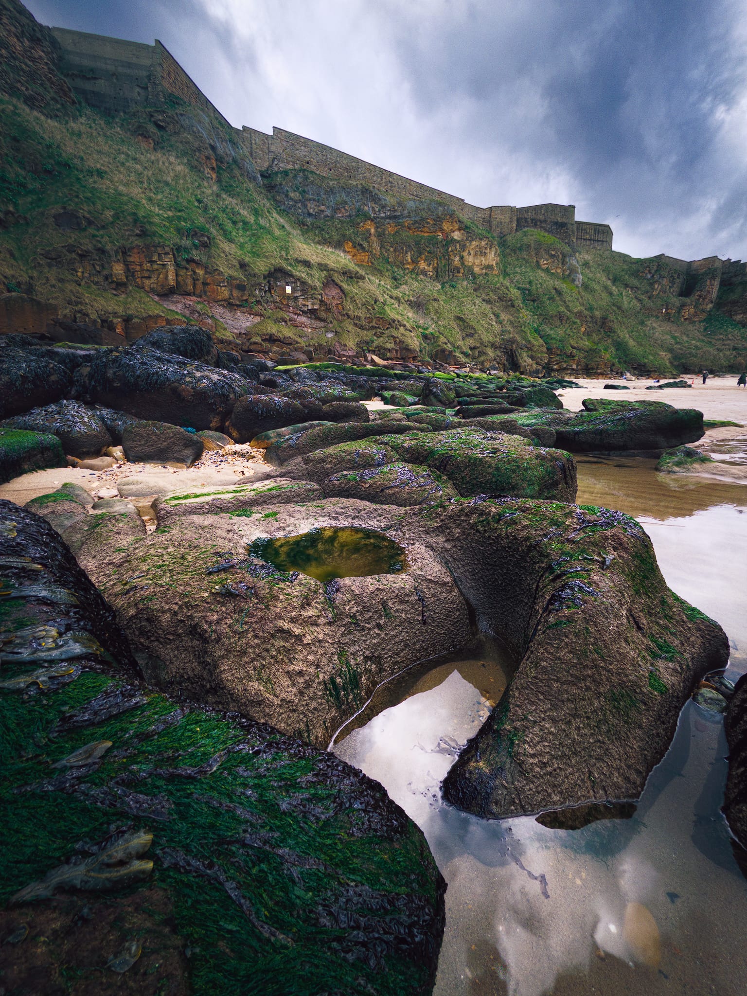 I wanted to explore the rockfall beneath the cliffs to see what fascinating geology there was. Plenty of seaweed and moss-covered boulders with wave-cut shapes made for lovely photos.