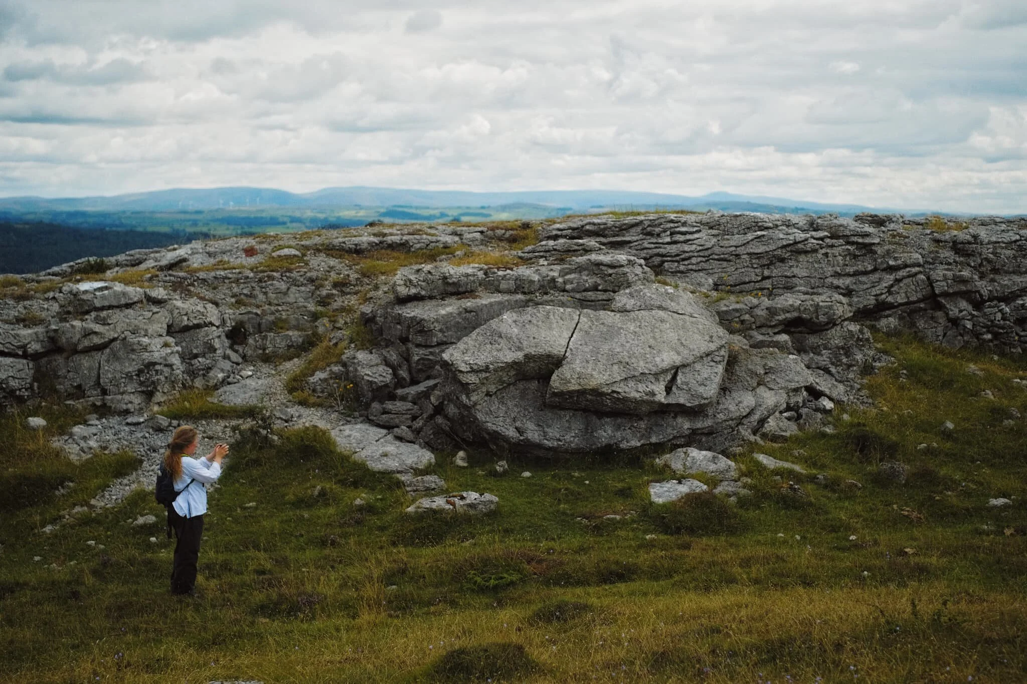 This is where you start to see some fantastic limestone formations and glacial erratics ahoy. My lovely Lisabet providing a sense of scale here. In the distance, a little to the right, you can just make out the unmistakeable shape of Ingleborough in the Yorkshire Dales.