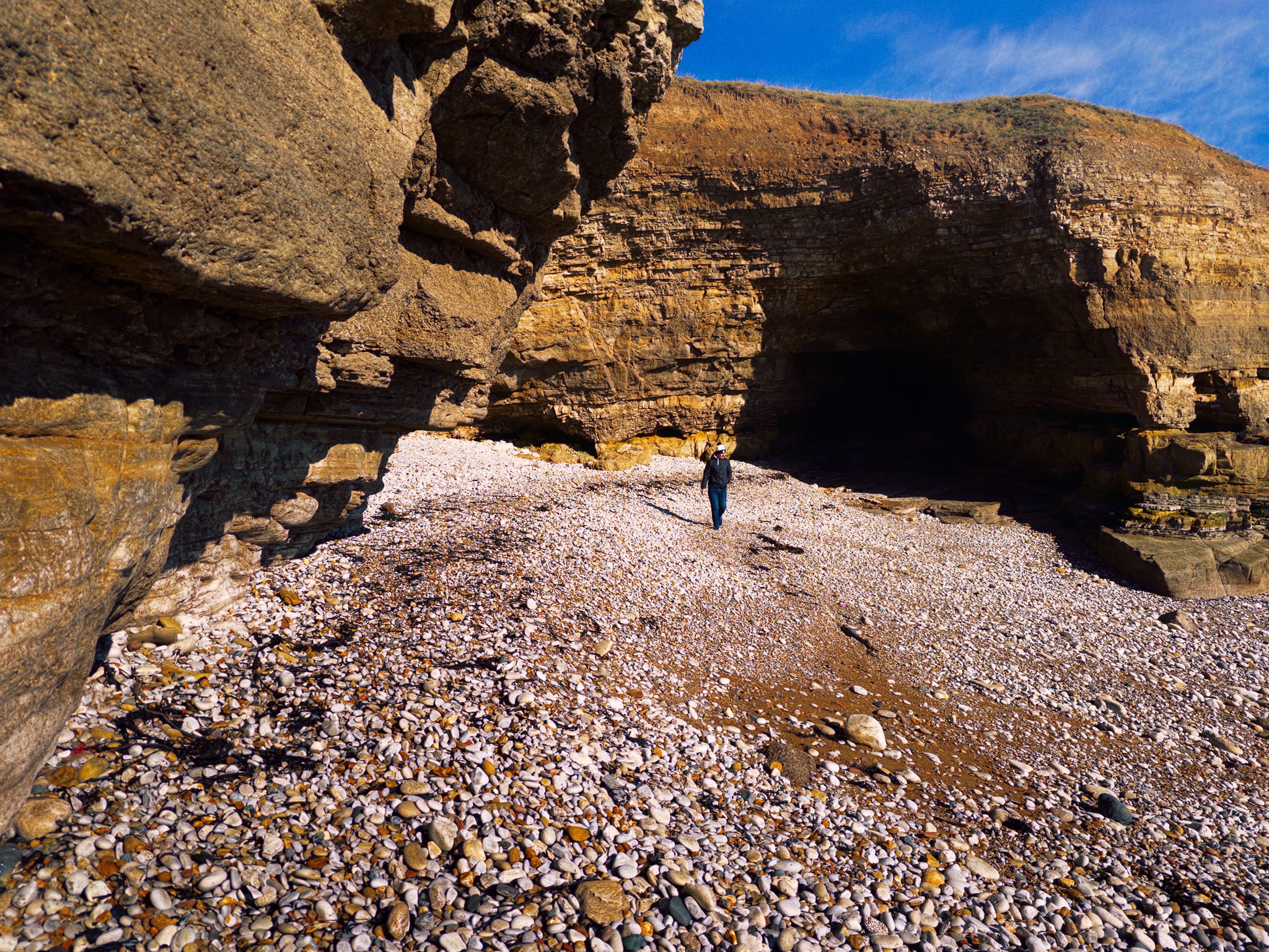 Evidence of the incomprehensible scale of geological time, where the water has carved out this little inlet between the cliffs. Happily, a fellow hiker provides scale.