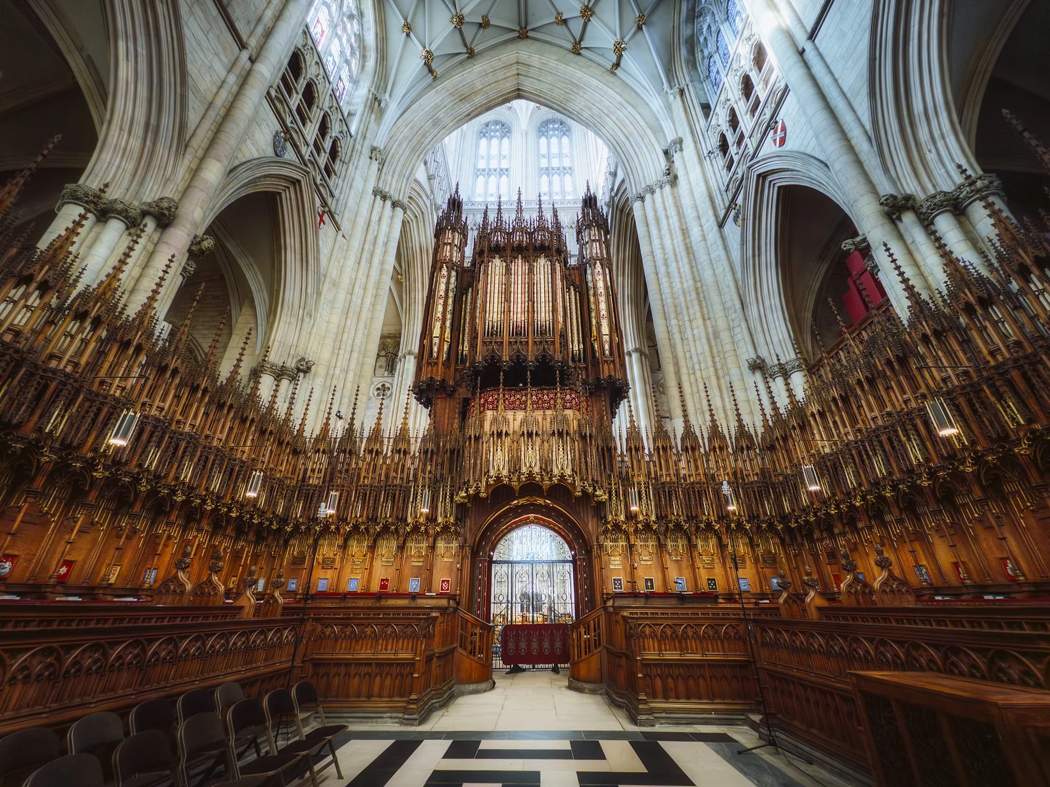  York Minster&rsquo;s magnificent organ in the Quire. The organ dates to 1632 when Charles I funded its construction, moving from the choir&rsquo;s north side to the screen in 1690. Described in 1730 as an elaborate instrument painted with the 150th Psalm, it was expanded by John Camidge into Britain&rsquo;s largest before the 1829 fire destroyed it. Elliot and Hill built an 8,000-pipe replacement in 1832—then the world&rsquo;s biggest—which was rebuilt in 1859 and 1903. It was modernided in 1918 and 1931, then more neo-classical elements added in 1960. Damaged in the 1984 fire, it was restored in 1991–1993 and completely refurbished in 2018–2021. 